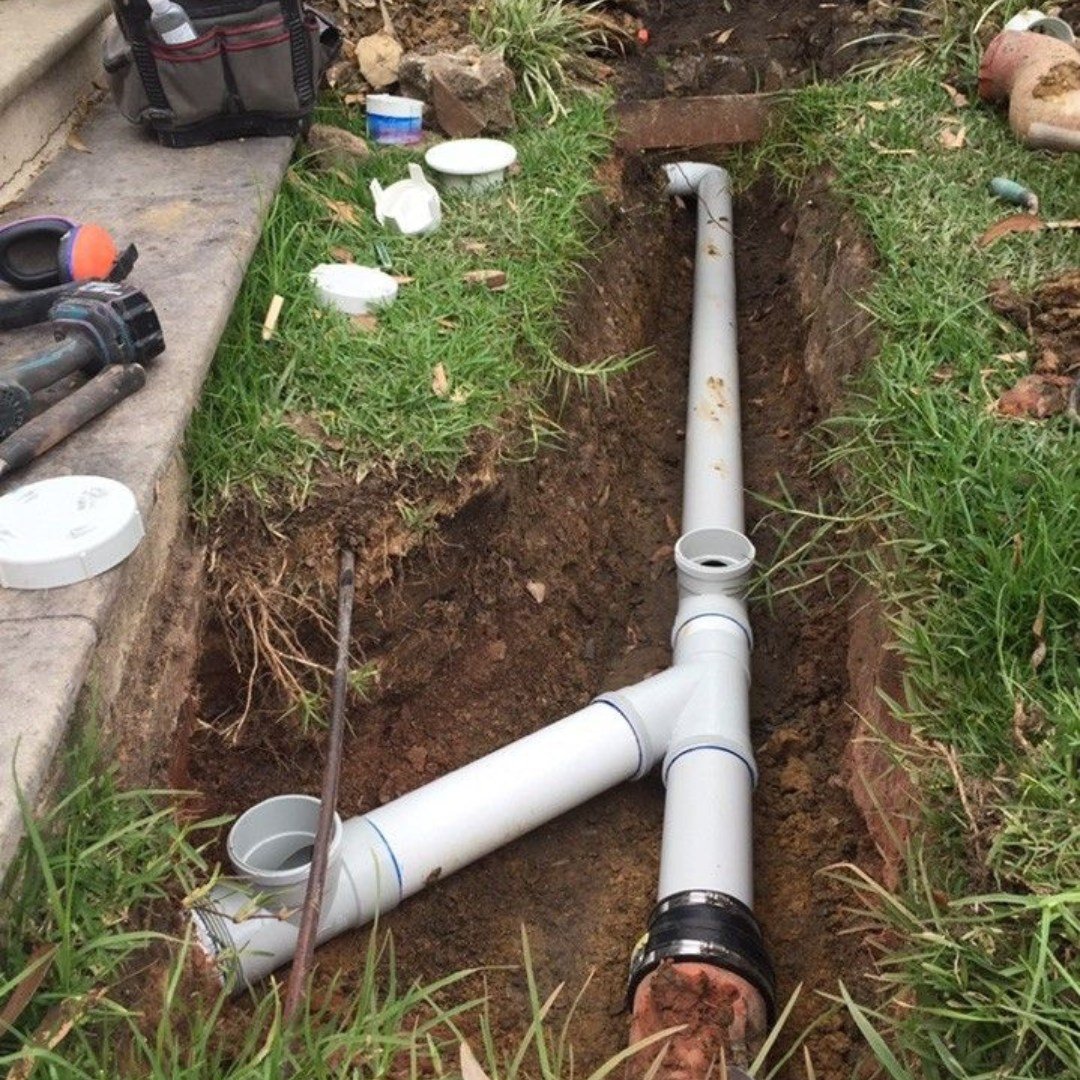 Buried PVC drain piping installed in a residential trench